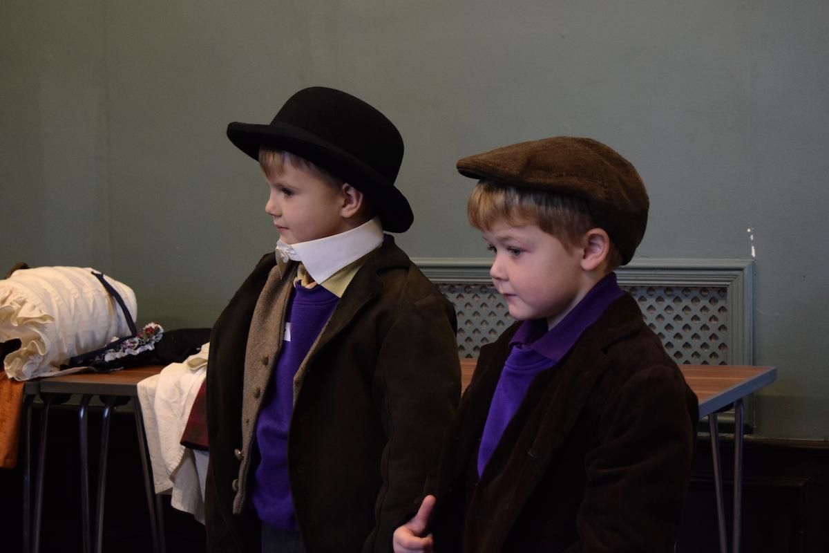 An image of two modern day children taking part in a Victorian school experience