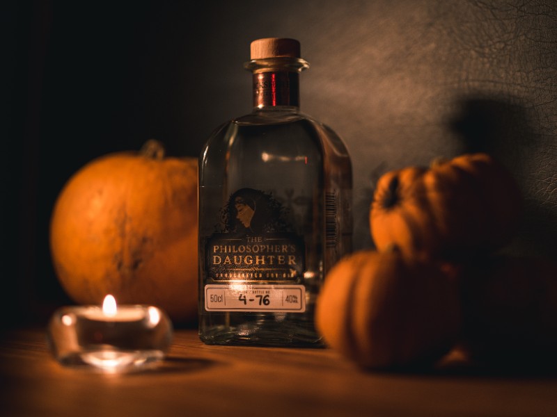 A bottle of gin surrounded by pumpkins