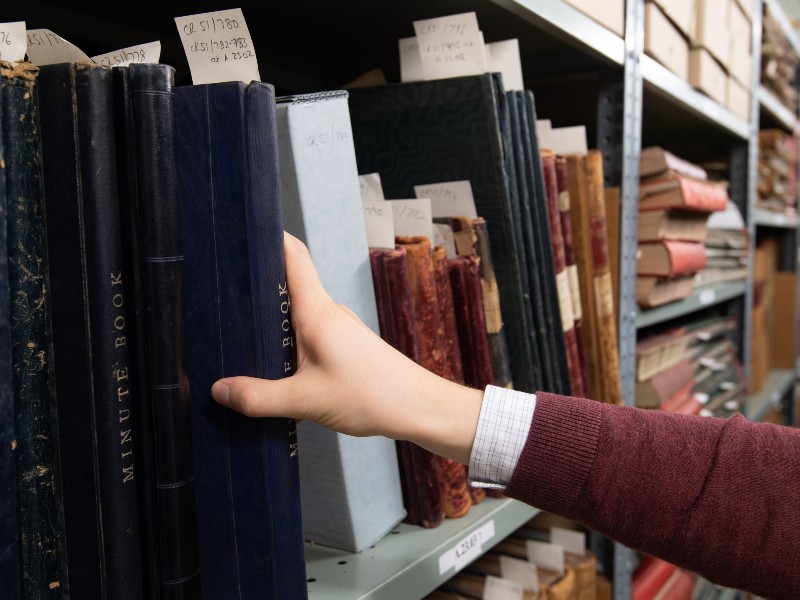 Someone looking through a shelf at Warwickshire County Record Office