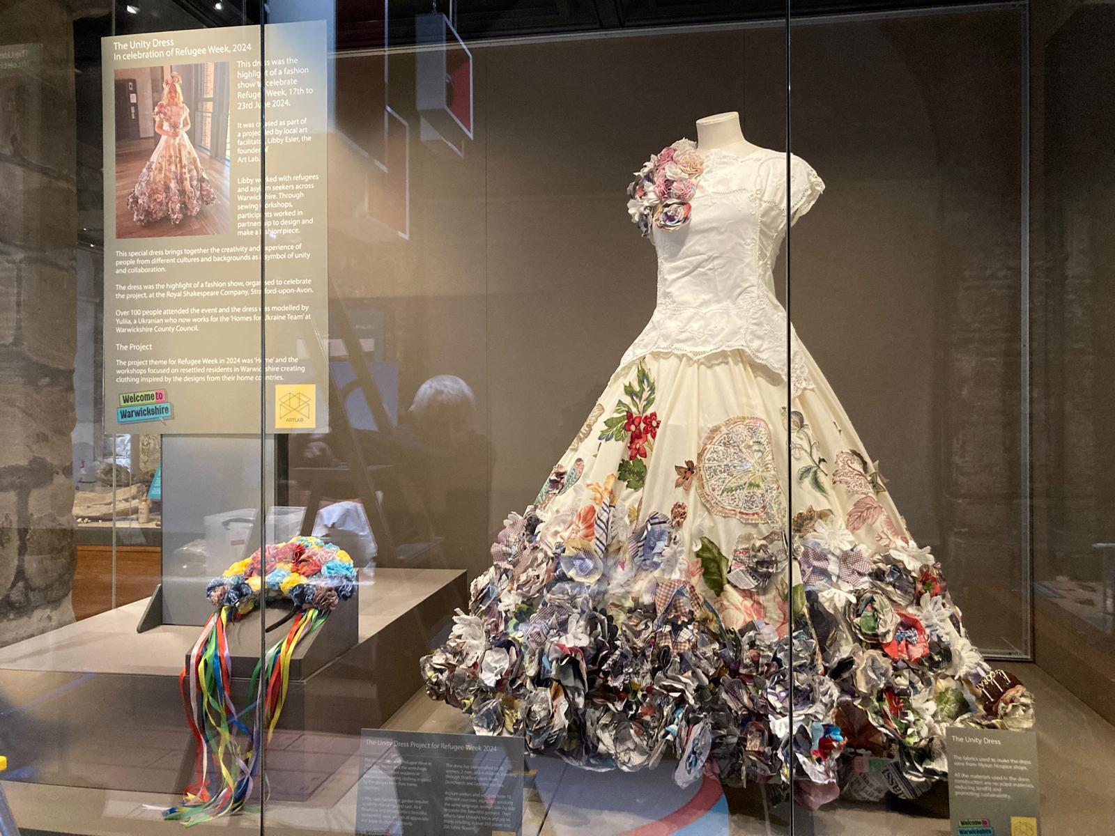 Picture of the floral Refugee Week dress on display at Market Hall Museum