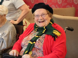 Person wearing a hat and scarf smiling