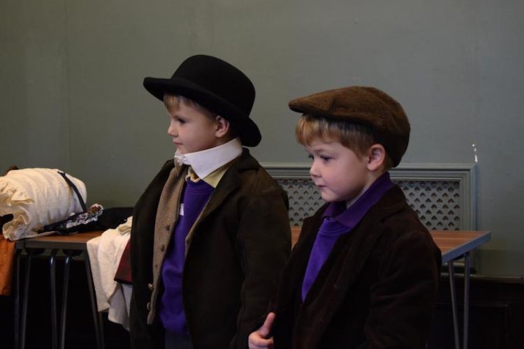A picture of two boys dressed up like Victorian children