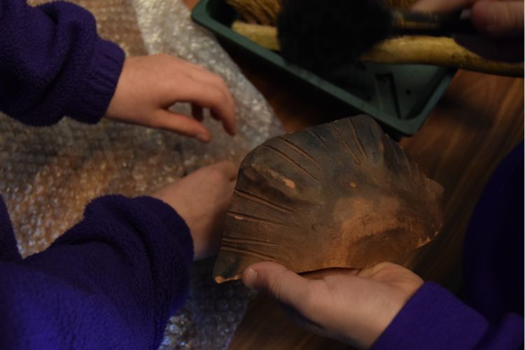 A picture of children holding a roman artefact