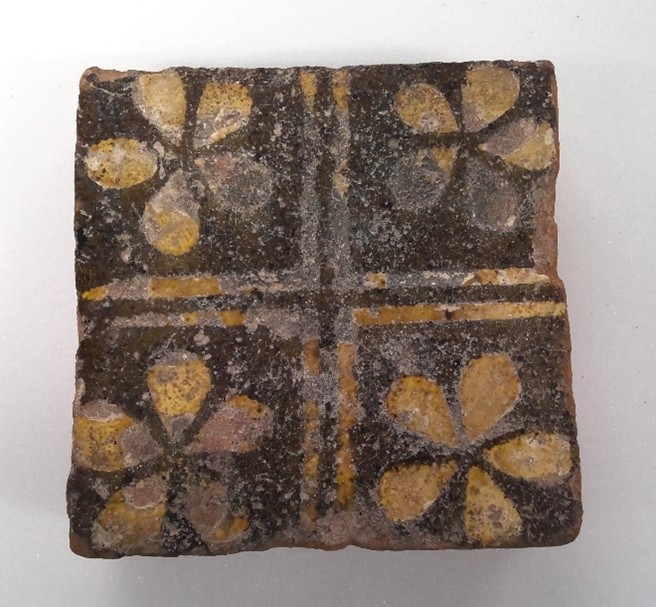 A floor tile with a pattern of four flowers.