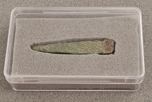 This object is called a strap end and is about 3cms long and made of bronze, it would have been a dull red gold colour when new and polished.
